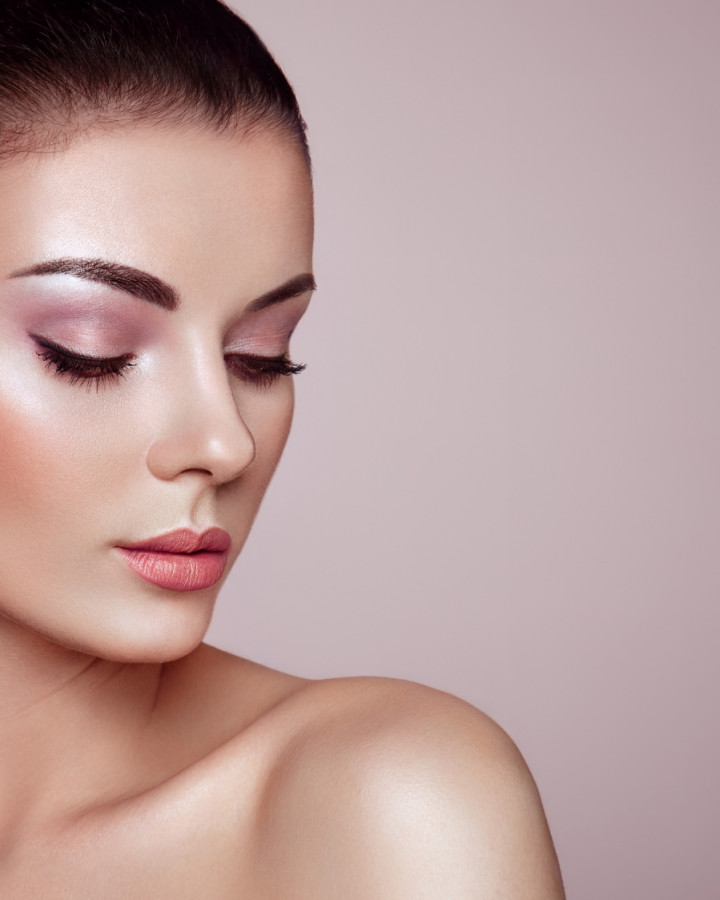 picture of a skin model with brown hair and a pink background